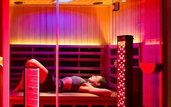 A person laying down in a red light therapy session.